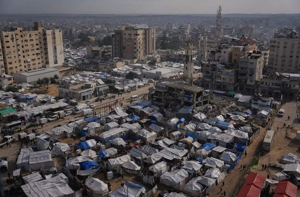 Palestinos caminan por las calles frente a campamentos de desplazados en la ciudad de Gaza, el miércoles 31 de diciembre de 2025