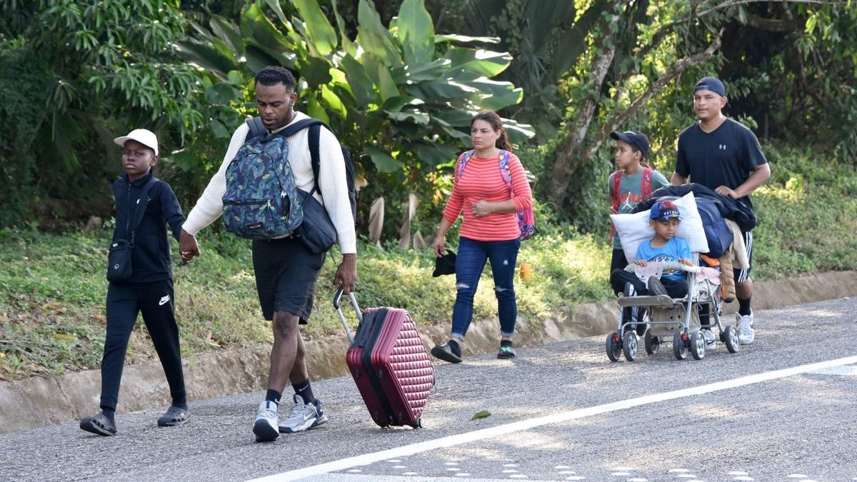 Migrantes caminan por una carretera en Huixtla