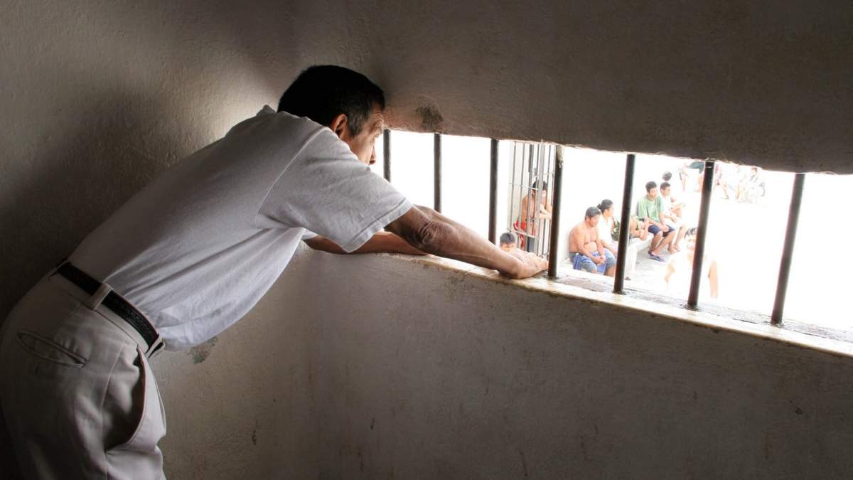 Un custodio vigilando a presos