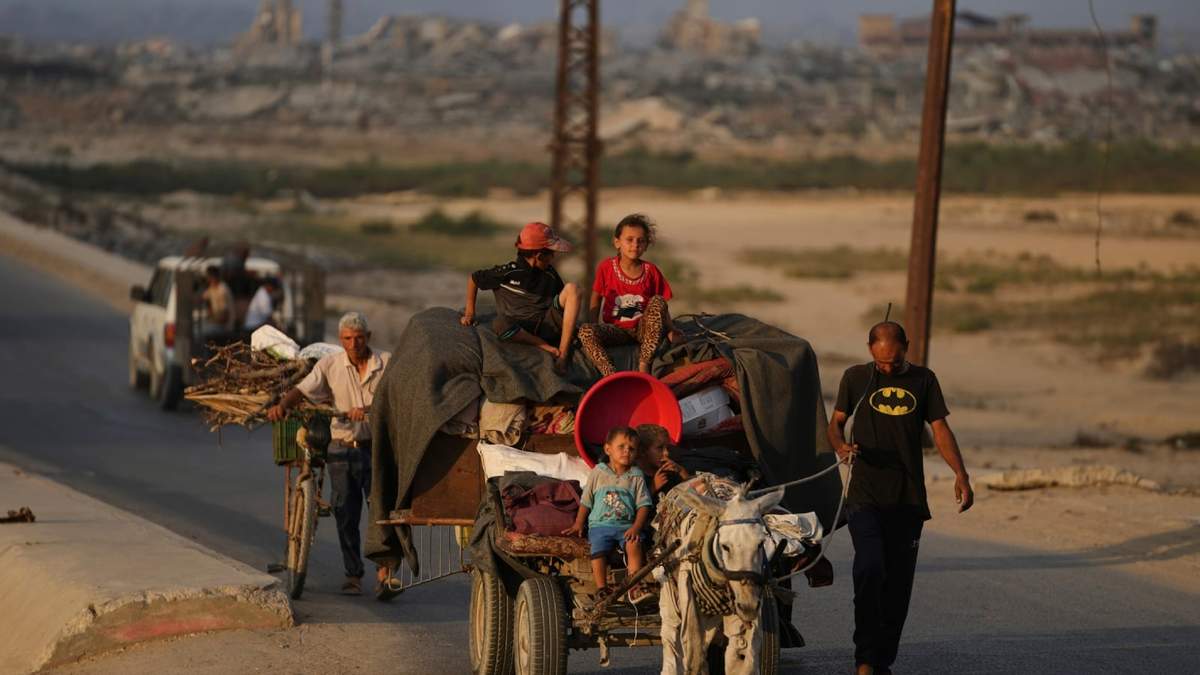 Palestinos desplazados que huyen del norte de Gaza llevan sus pertenencias por la carretera costera hacia el sur de Gaza