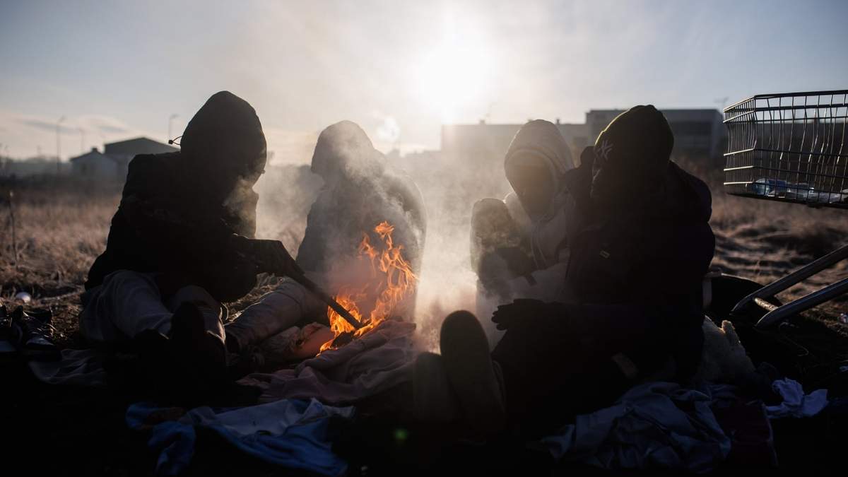 Refugiados preparan una hoguera en Medyka, frontera de Polonia con Ucrania