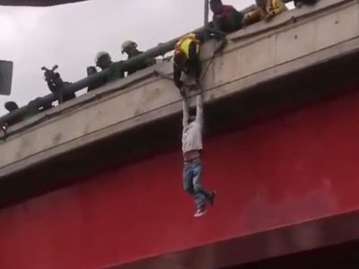 Un hombre intenta lanzarse de un puente, lo disuaden y cae en el intento de rescatarlo