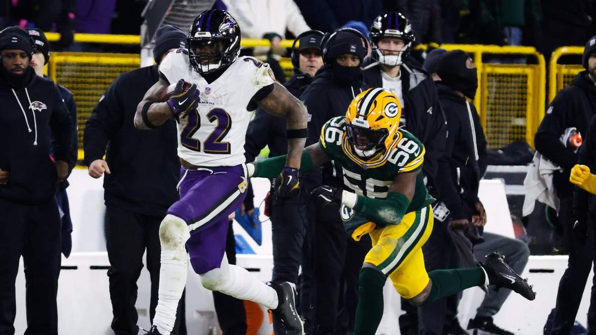 El corredor de los Ravens de Baltimore Derrick Henry corre con el balón mientras lo persigue el linebacker de los Packers de Green Bay Edgerrin Cooper