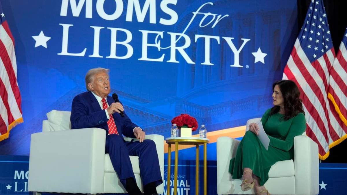 Donald Trump habla con la cofundadora de Moms for Liberty Tiffany Justice durante un acto en la convención anual del grupo en Washington