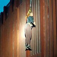 'Polleros” abandonan a una mujer y se queda colgada en el muro fronterizo