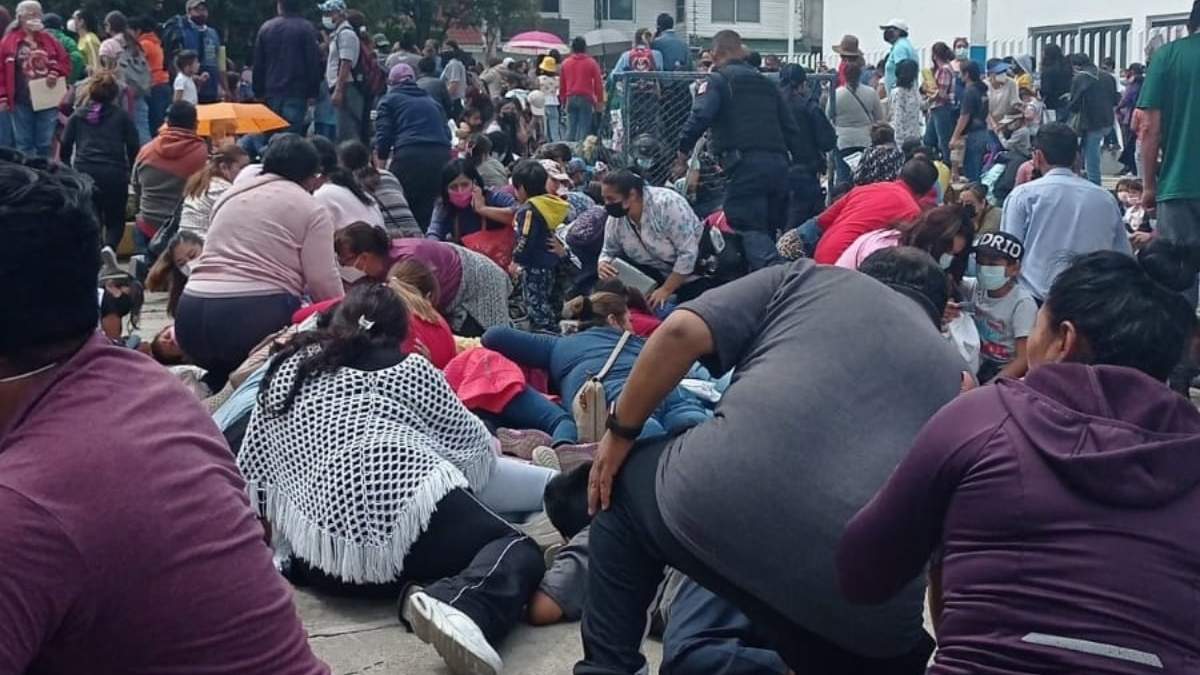 Personas se resguardan durante la balacera en el centro de vacunación en Puebla