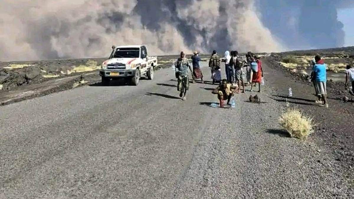U grupo de personas observa la columna de cenizas de una erupción del volcán Hayli Gubbi, en la región de Afar, Etiopía