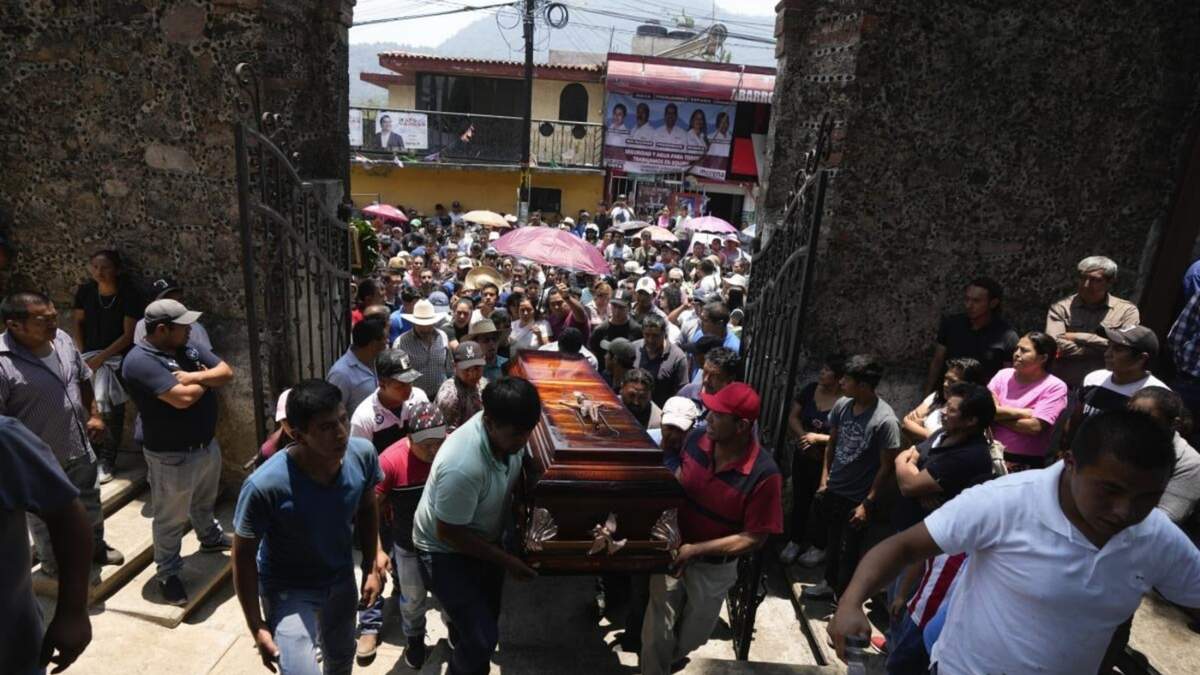 Parientes y amigos introducen a una iglesia el ataúd con los restos de un hombre asesinado en una masacre para una misa fúnebre en su honor, el martes 14 de mayo de 2024, en Huitzilac