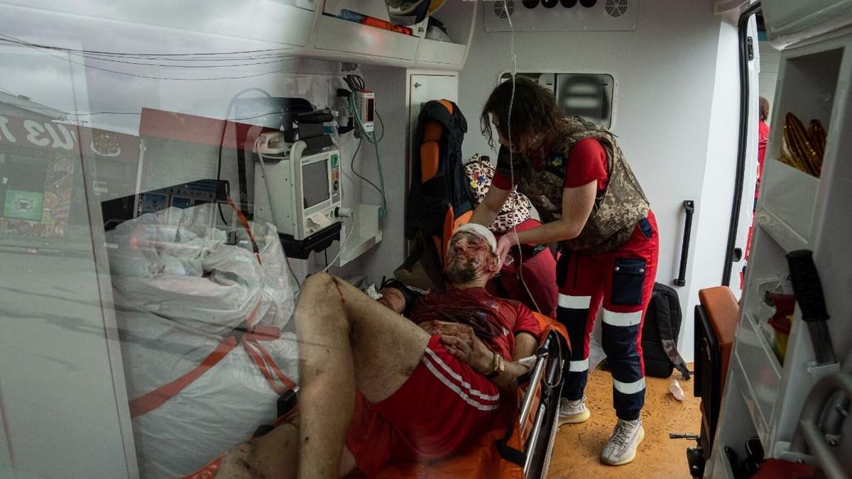Un hombre herido es atendido tras un ataque ruso al mercado de Barabashovo, en Járkiv, Ucrania