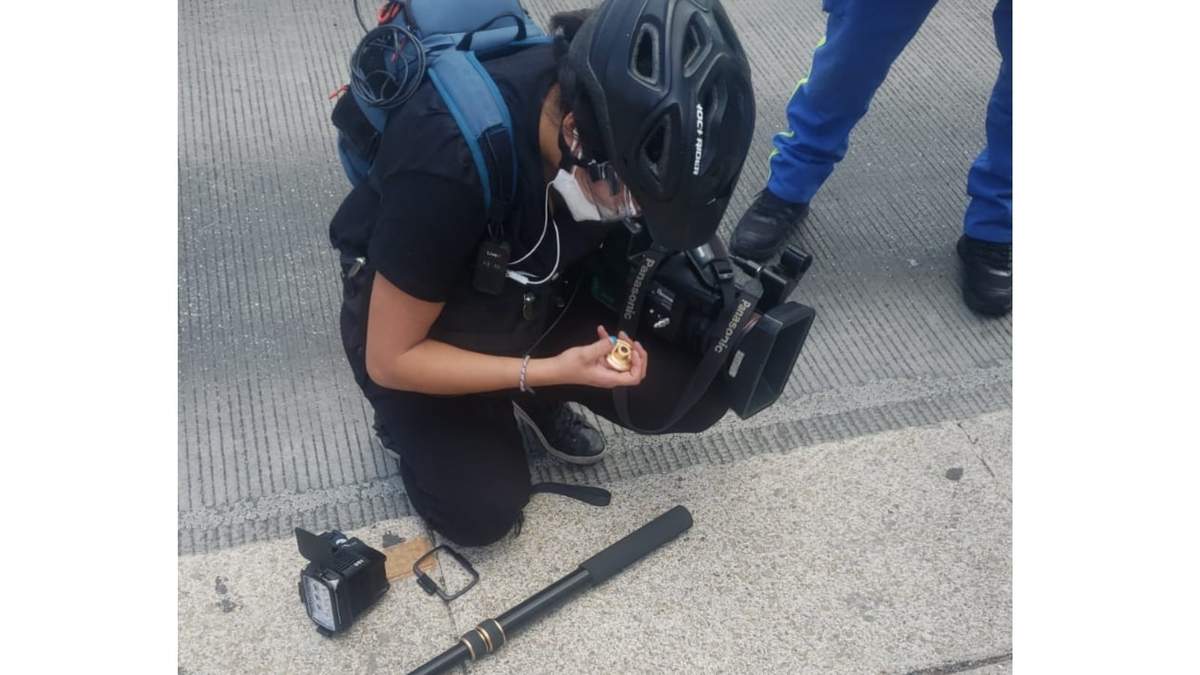 La camarógrafa de Televisa revisa el equipo roto