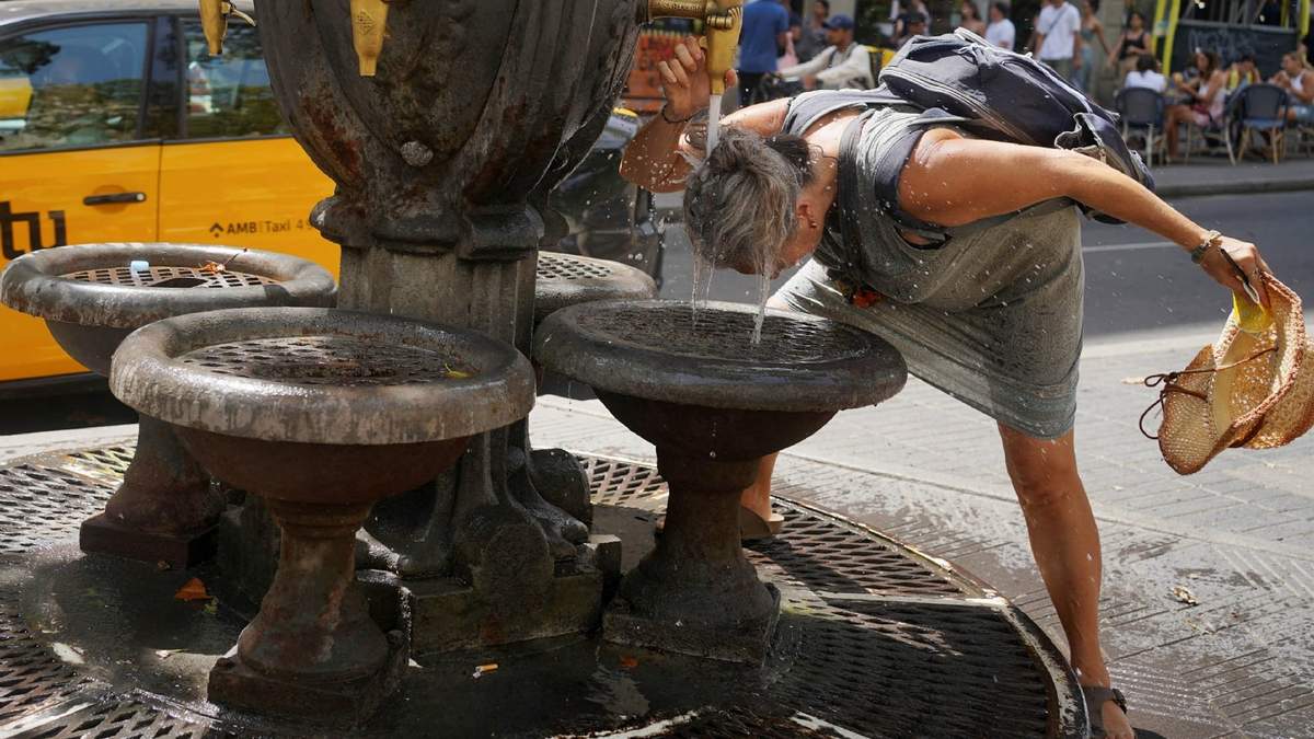 ARCHIVO. Una turista se refresca en una fuente en medio de una ola de calor