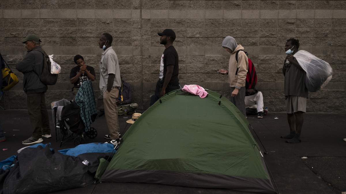 ARCHIVO - Indigentes hacen una fila a la espera de recibir alimentos, afuera de la Misión Midnight en el área de Skid Row, en Los Ángeles, el miércoles 25 de octubre de 2023. ()