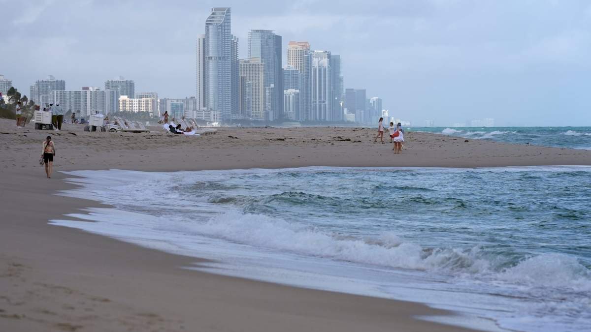 Personas caminan por la playa en Surfside, Florida, cerca de Sunny Isles Beach, el martes 17 de diciembre de 2024
