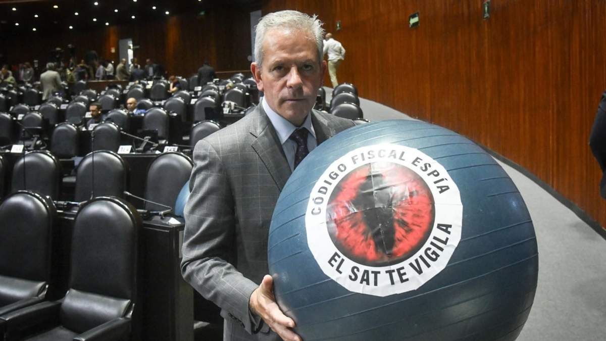 Marcelo Torres Cofiño, diputado del PAN, sostiene una pelota con la frase "Código Fiscal Espía, el SAT te vigila" que forma parte de la miscelánea fiscal durante la sesión en la Cámara de Diputados