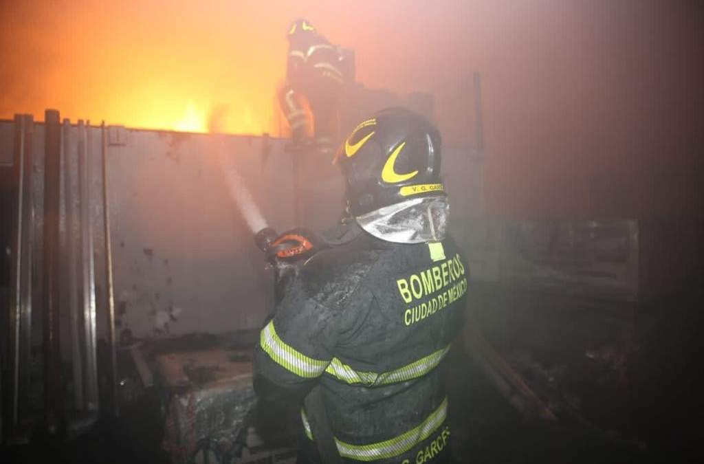 Bomberos de la Ciudad de México llevan a cabo acciones para sofocar el incendio ocurrido en una bodega de azulejos en Cuchilla Pantitlán