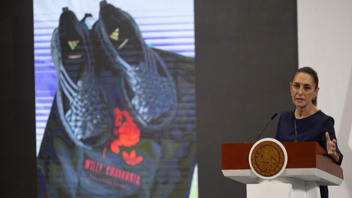 La presidenta Claudia Sheinbaum en la conferencia matutina de Palacio Nacional con los "Oaxaca Slip on" de Willy Chavarría y Adidas, de fondo, el viernes 9 de agosto de 2025
