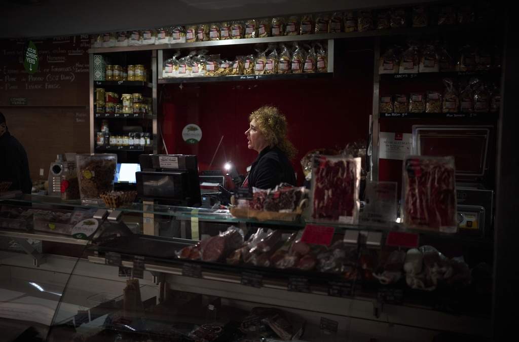 Vendedores utilizan la luz de sus celulares para elegir comida durante el apagón generalizado, Barcelona, lunes 28 de abril de 2025