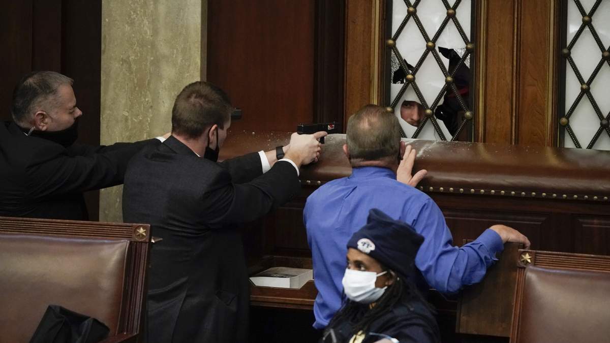 Policías del Capitolio apuntan a manifestantes que intentan ingresar