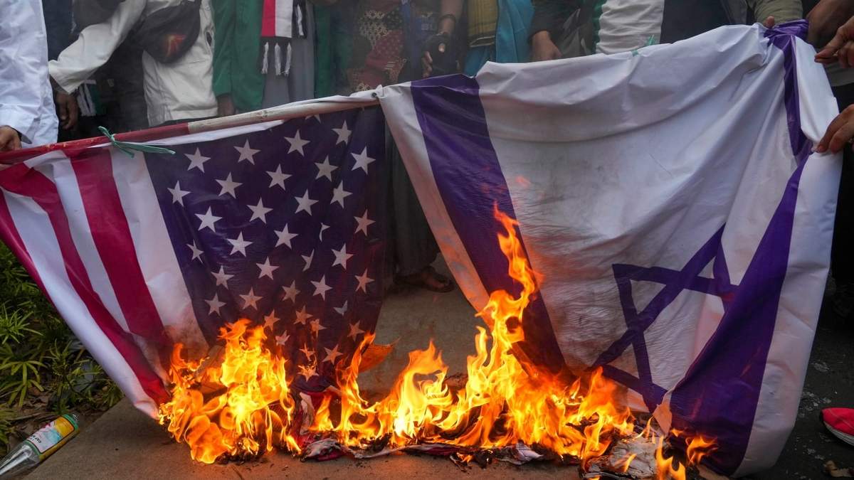 Manifestantes musulmanes queman banderas de Estados Unidos e Israel durante una protesta en Yakarta, Indonesia
