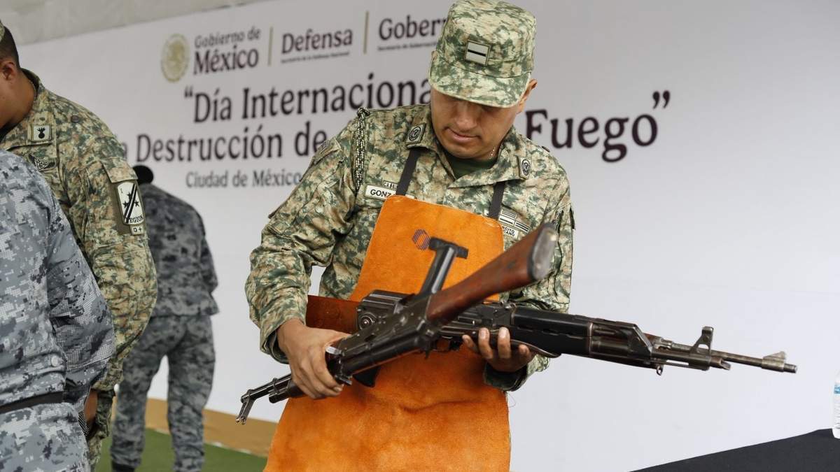 Elemento del Ejército sostiene armas recuperadas en la ceremonia por el Día Internacional de la Destrucción de Armas de Fuego