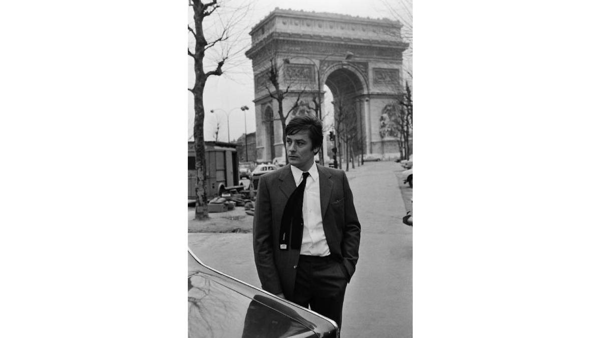 Alain delon en sus años de juventud frente al Arco del Triunfo