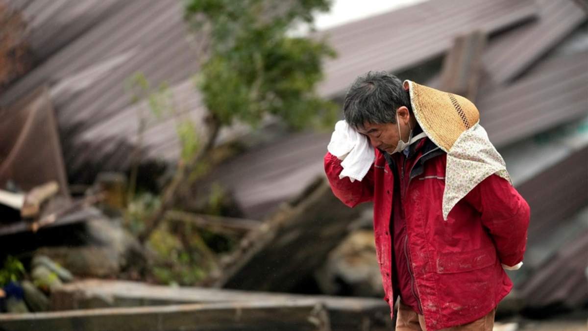 Un hombre llora mientras encuentran los restos de un familiar entre los restos de una vivienda que se vino abajo por un potente sismo en Suzu, en la prefectura de Ishikawa, Japón