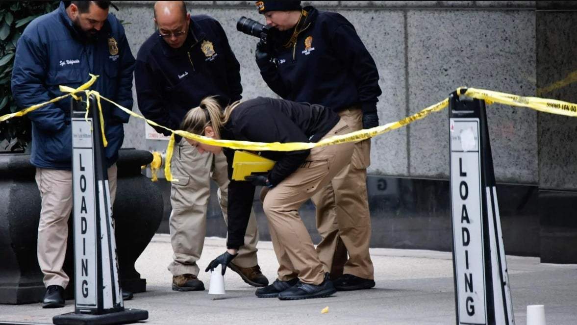Agentes de la unidad de asesinatos de la policía de Nueva York colocan vasos para marcar los lugares donde cayeron las balas mientras investigan en las inmediaciones del hotel Hilton de Manhattan, donde Brian Thompson, CEO of UnitedHealthcare, fue asesinato a tiros