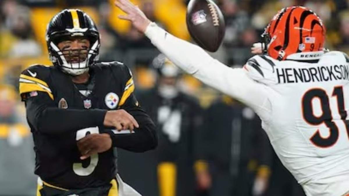 El QB de los Steelers de Pittsburgh, Russell Wilson (3), lanza un pase mientras el ala defensiva de los Bengals de Cincinnati, Trey Hendrickson (91), se acerca durante la primera mitad de un partido de fútbol americano de la NFL en Pittsburgh