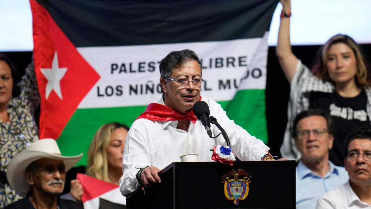 Partidarios del presidente colombiano Gustavo Petro sujetan una bandera palestina mientras Petro habla en un evento en Ibague, Colombia