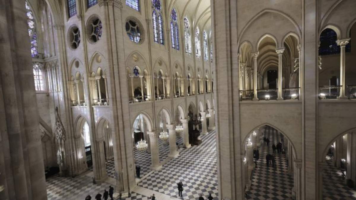 Varias personas realizan un recorrido en el interior de la catedral de Notre-Dame de París durante una visita del presidente francés Emmanuel Macron