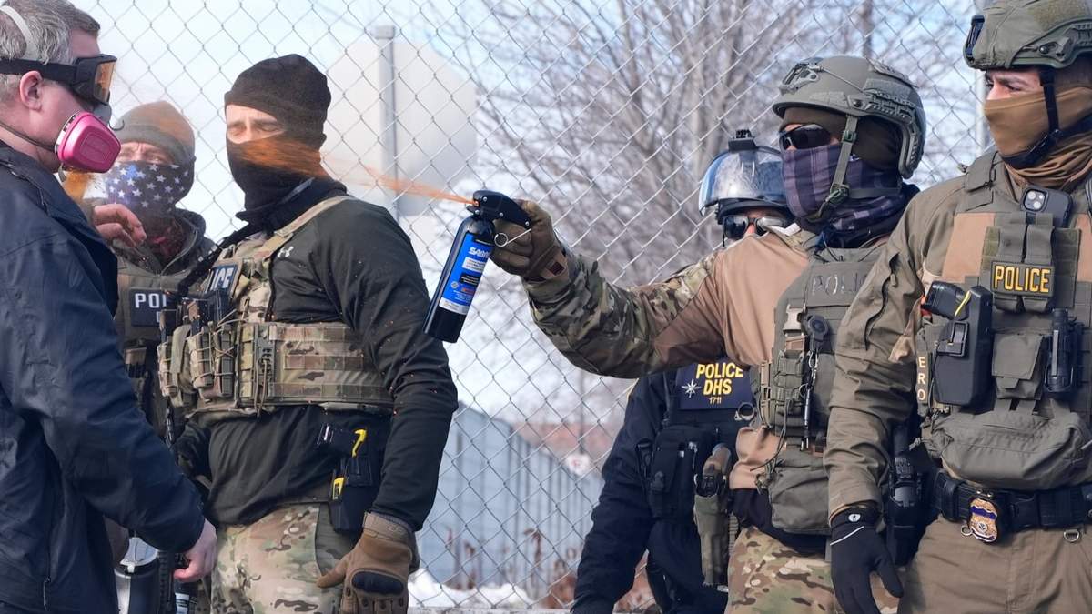 Un agente de ICE rocía con gas pimienta a un manifestante frente al edificio federal Bishop Whipple, este lunes