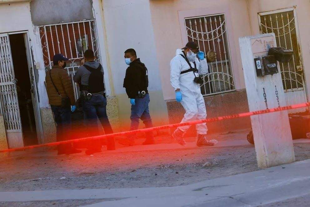 Autoridades realizan labores en una vivienda donde hallaron los cadáveres de tres mujeres degolladas en Ciudad Juárez, Chihuahua