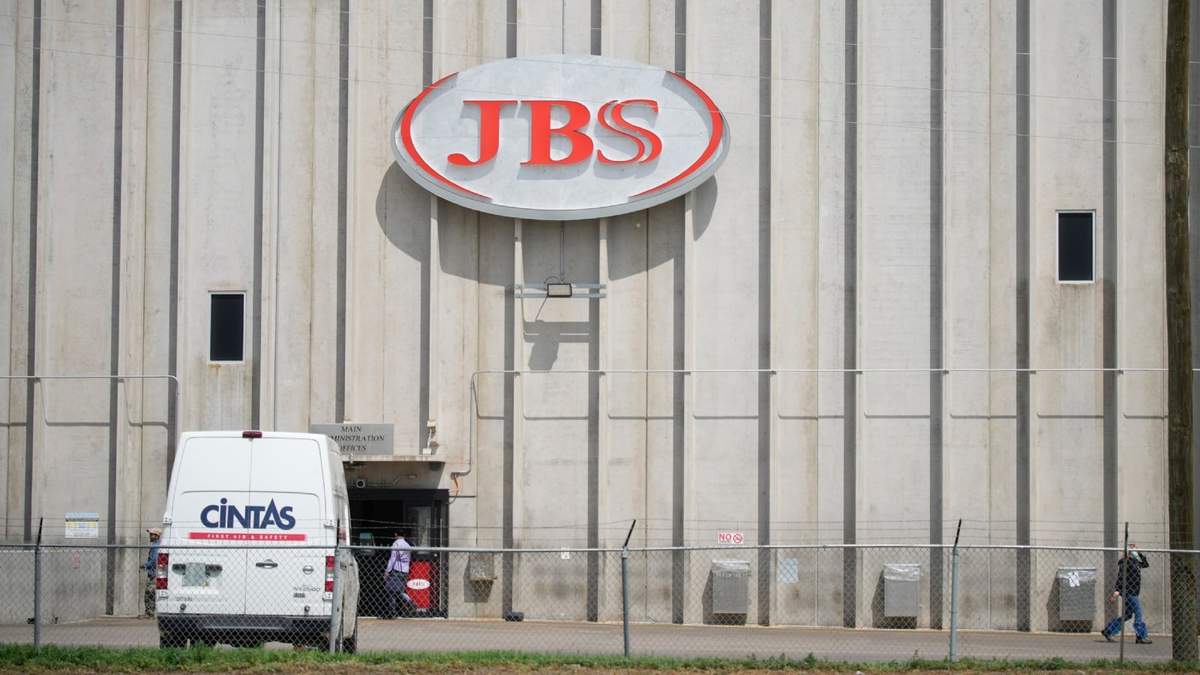 Empleados trabajan ante la entrada de la planta de procesamiento de carne de JBS, el 23 de julio de 2021, en Greeley, Colorado