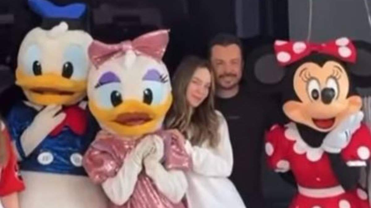 La cantante Belinda y José Luis García Parra, coordinador del gabinete del morenista Alejandro Armenta Mier, posan con personajes en Disneylandia