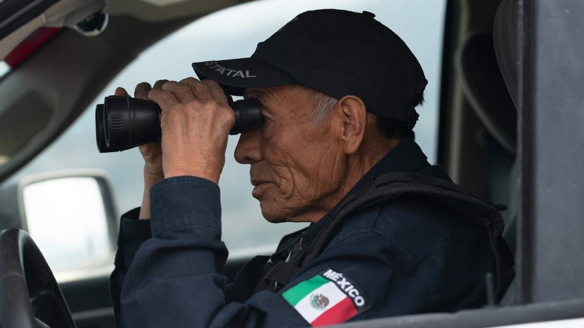 Nefi de Aquino, quien trabaja como oficial de policía y también vigila la actividad del Popocatépetl, observa el volcán a través de sus binoculares desde Santiago Xalitzintla
