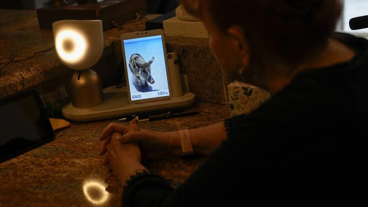 Deanna Dezern, de 83 años, interactúa con su ElliQ, un dispositivo de mesa que utiliza inteligencia artificial para mantener conversaciones similares a las humanas
