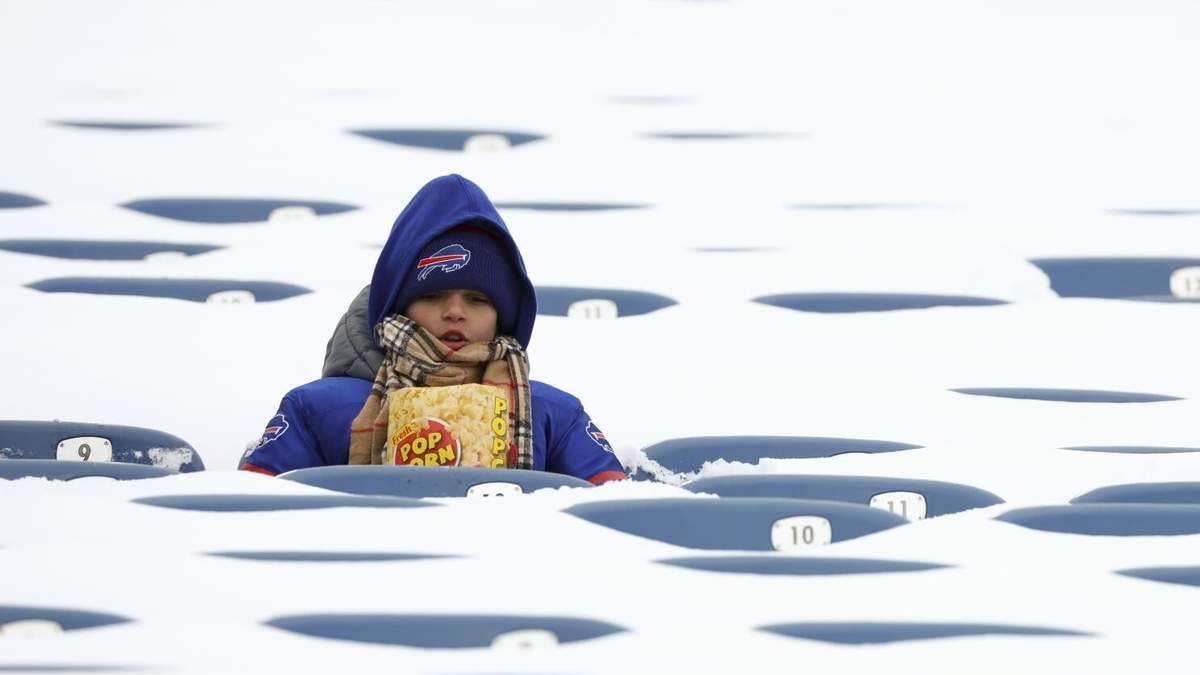 Un aficionado de los Buffalo Bills se sienta entre asientos llenos de nieve al inicio de un juego de wild-card de la NFL entre los Buffalo Bills y los Steelers de Pittsburgh