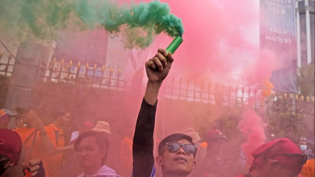 Un trabajador sostiene una bengala durante una manifestación del Primero de Mayo en Yakarta, Indonesia. Trabajadores y activistas en Asia reclamaban salarios más altos y mejores condiciones de trabajo, entre otras demandas