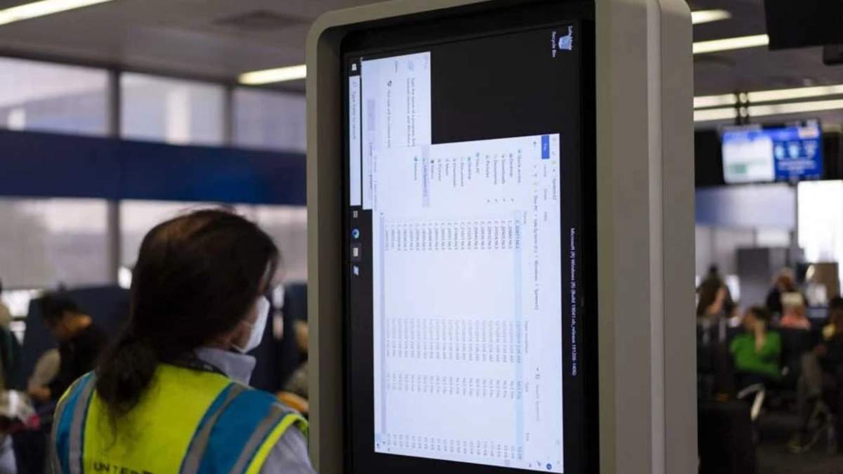 Una técnico trabaja en un monitor de información cerca de la zona de embarque de United Airlines en el aeropuerto internacional O'Hare en Chicago, tras apagón tecnológico