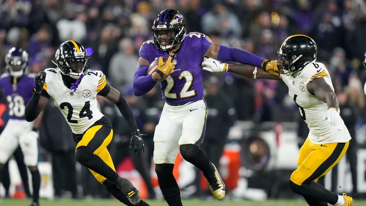 El corredor de los Ravens de Baltimore, Derrick Henry (22), se separa del apoyador de los Steelers de Pittsburgh, Patrick Queen (6) y del esquinero Joey Porter Jr. (24), en su camino a anotar un touchdown por tierra durante la segunda mitad del juego de comodín de la AFC