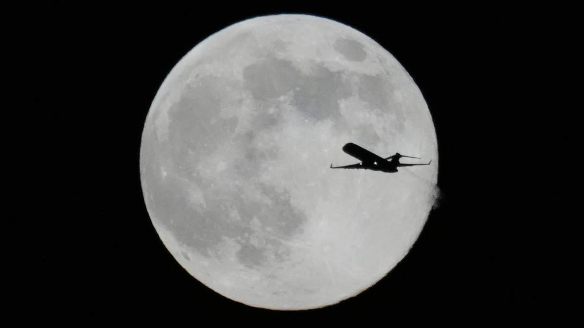 Un avión vuela frente a una super Luna, el jueves 4 de diciembre de 2025 en Chicago