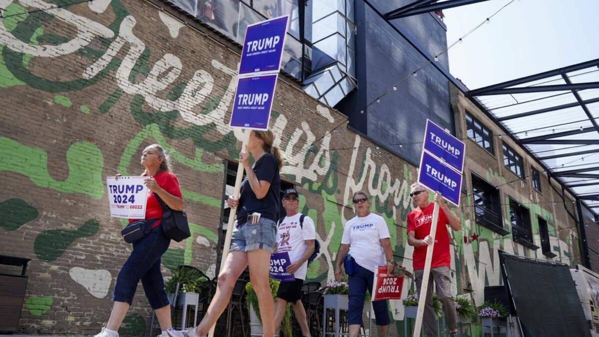 Simpatizantes del expresidente Donald Trump caminan cerca del Fiserv Forum, donde se llevará a cabo el primer debate republicano de estas primarias, en Milwaukee