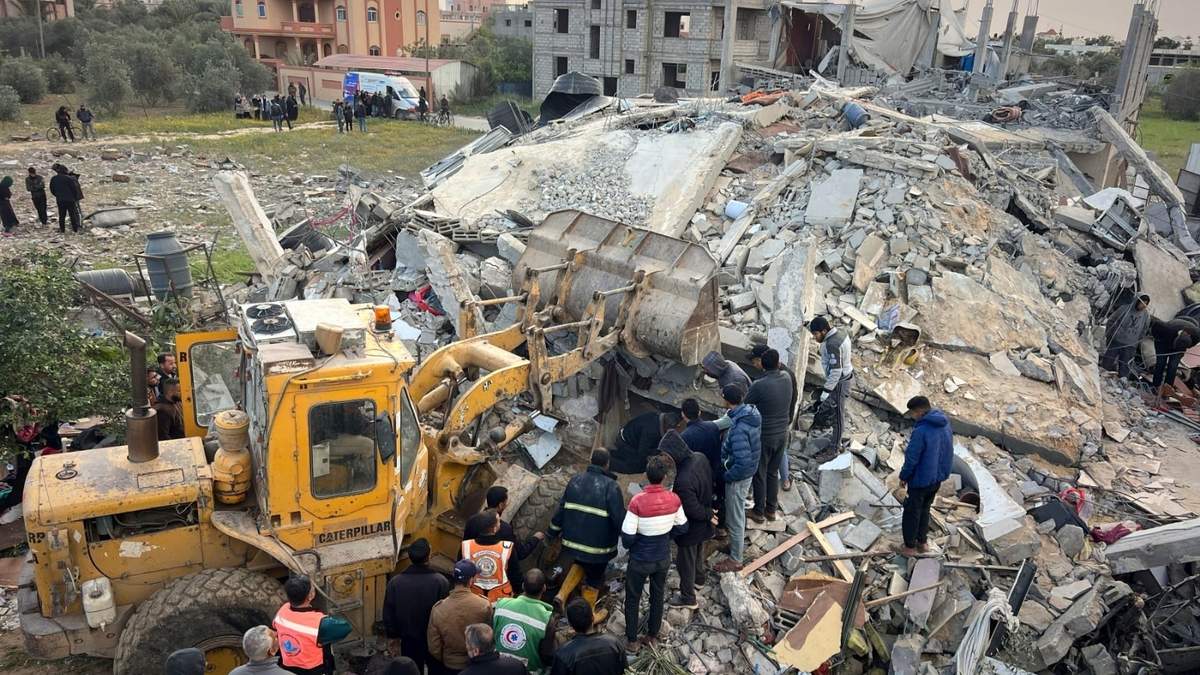 Voluntarios y rescatistas utilizan una topadora para retirar escombros de un edificio golpeado por un ataque aéreo israelí en Jan Yunis, en el sur de la Franja de Gaza, el jueves 20 de marzo de 2025
