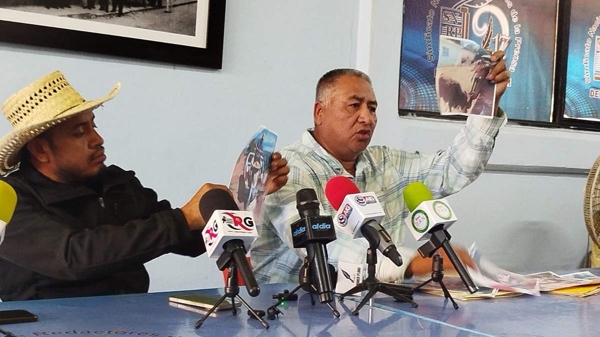 Los dirigentes Jesús Placido y Lino Santos muestran fotos de la detención del hermano de Lino por parte de autoridades por defenderse de la delincuencia