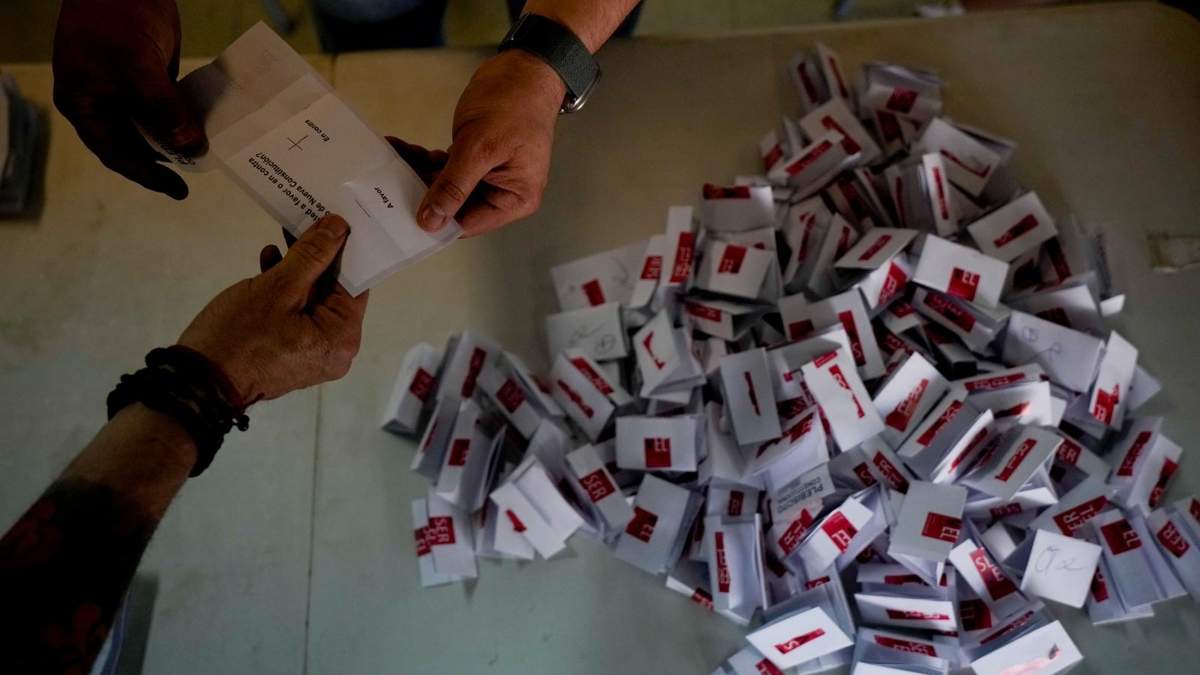 Trabajadores electorales abren los votos para el conteo tras el cierre de urnas en Santiago