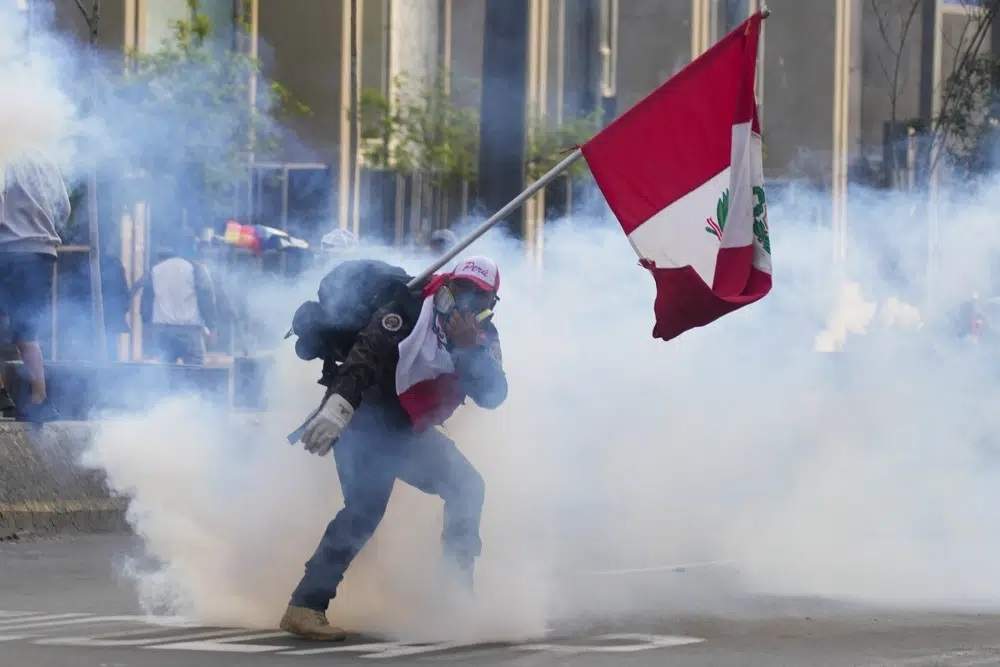 Un simpatizante del destituido presidente Pedro Castillo devuelve un contenedor de gas lacrimógeno en dirección a la policía, el 12 de diciembre de 2022, en Lima, Perú