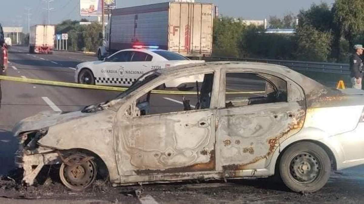 Una patrulla de la Guardia Nacional al lado del vehículo incendiado