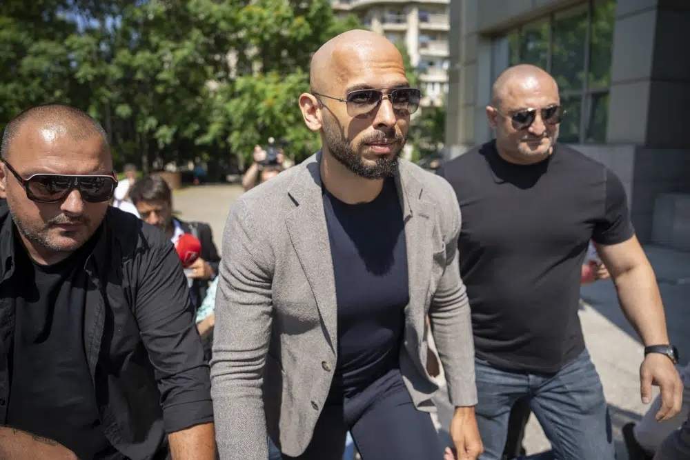 Andrew Tate camina entre guardaespaldas a su llegada a un tribunal en Bucarest, Rumanía, el 21 de junio de 2023