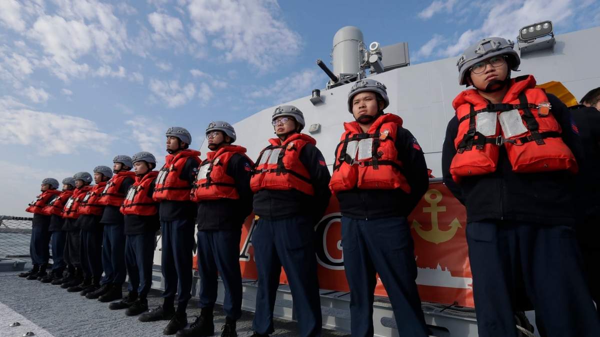 Tripulantes de la Armada taiwanesa se ven de pie junto a una patrullera de fabricación taiwanesa Tuo Chiang durante un simulacro de ataque en la ciudad de Kaohsiung, en el sur de Taiwán