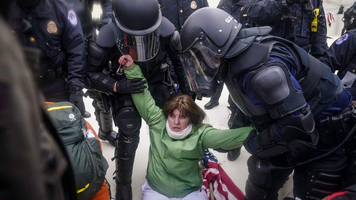 Una mujer es levantada por policías frente al Capitolio de Estados Unidos